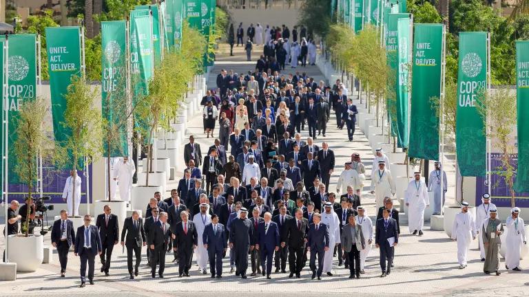 Dozens of world leaders walking down a pathway at Expo City Dubai during the UN Climate Change Conference COP28