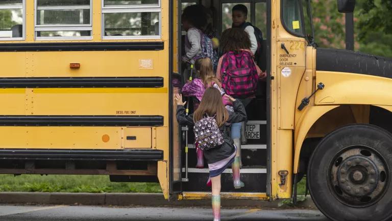 Elementary school students boarding a school bus.