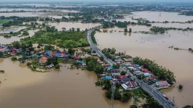 An aerial view of floodwaters overtaking a cluster of buildings