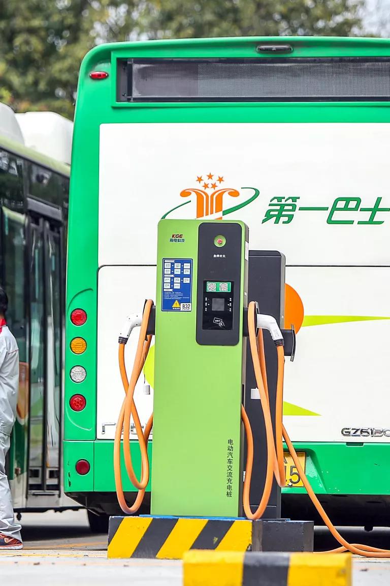 Two drivers charging two electric buses in China
