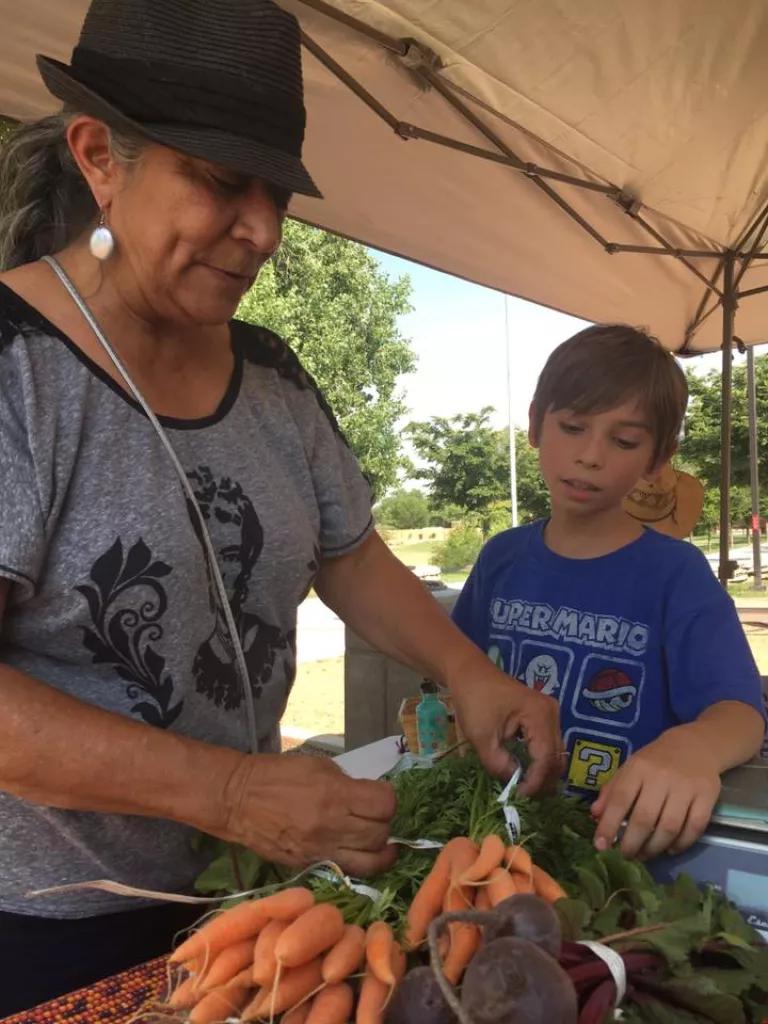 Sofia Martinez, Co-Director of Los Jardines Institute, with local produce at La Familia Growers Market in the South Valley of Albuquerque, New Mexico 